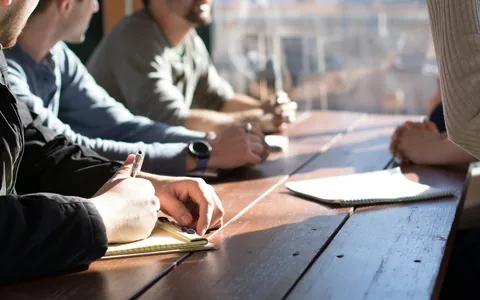 Colleagues collaborating around an office meeting table.