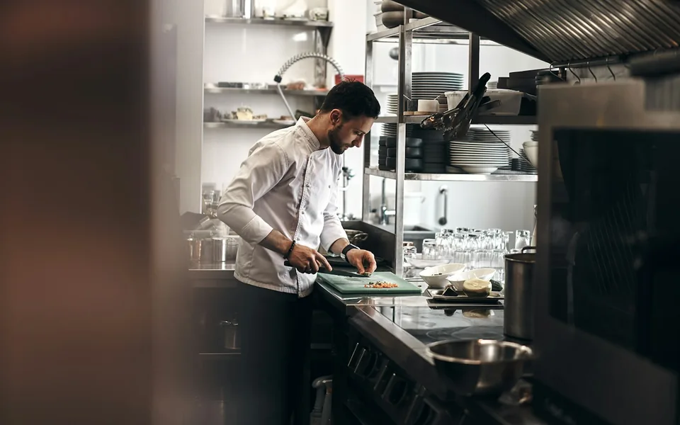 Chef preparing ingredients in a commercial kitchen.