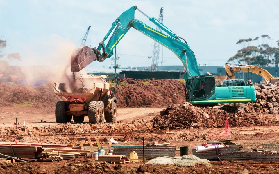 Excavator loading soil into a dump truck.