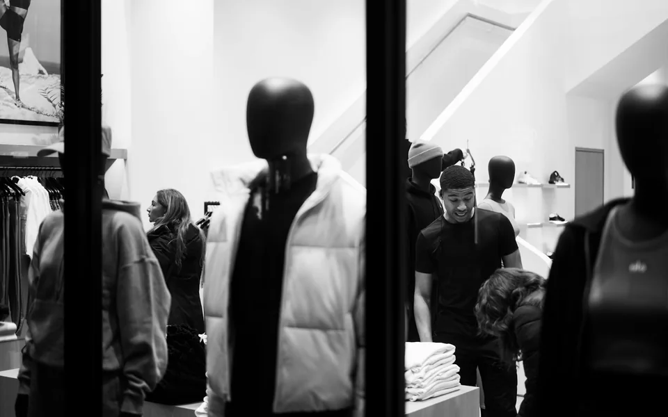 Mannequins and shoppers in a clothing store.