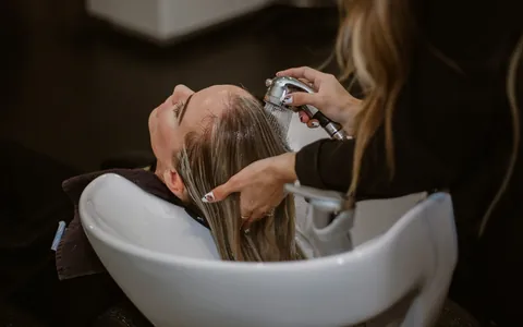 Hair stylist washing a client's hair in a salon.